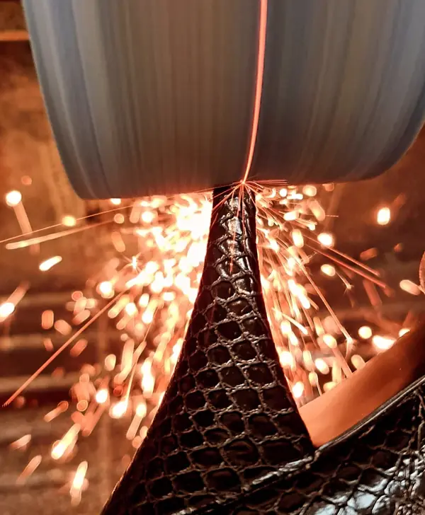 Lowering a heel on the finishing machine, sparks flying