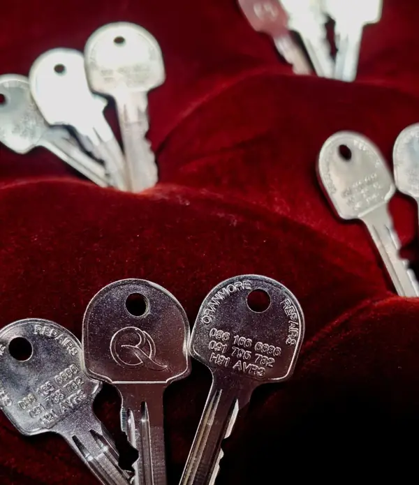 Freshly cut keys engraved with the Oranmore Repairs logo, on red velvet